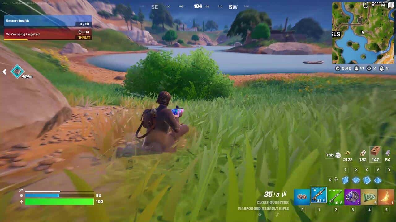 Fortnite best hiding spots: A player sliding towards a bush next to a lake in Fortnite.