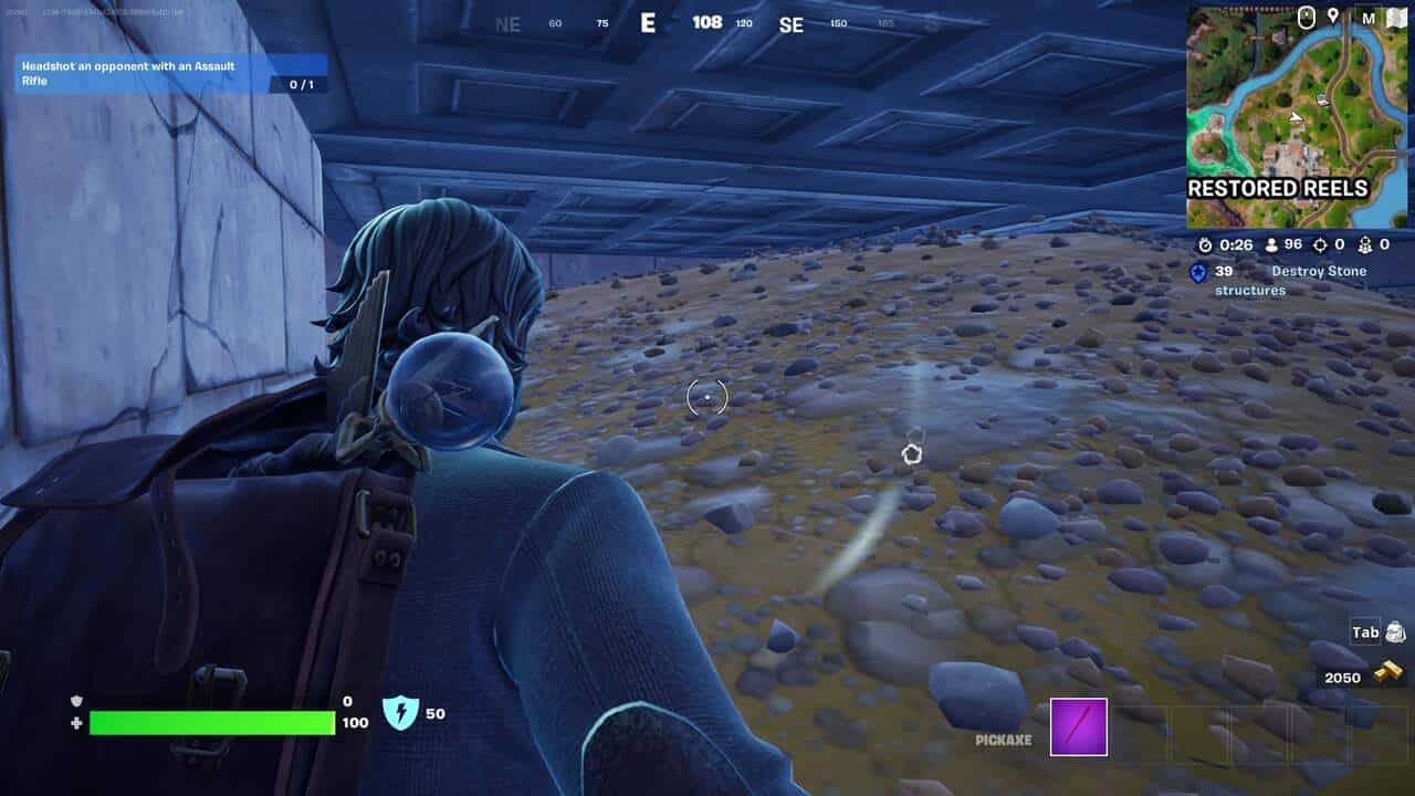 Fortnite best hiding spots: A player hiding under a building next to a pile of rubble in Fortnite.