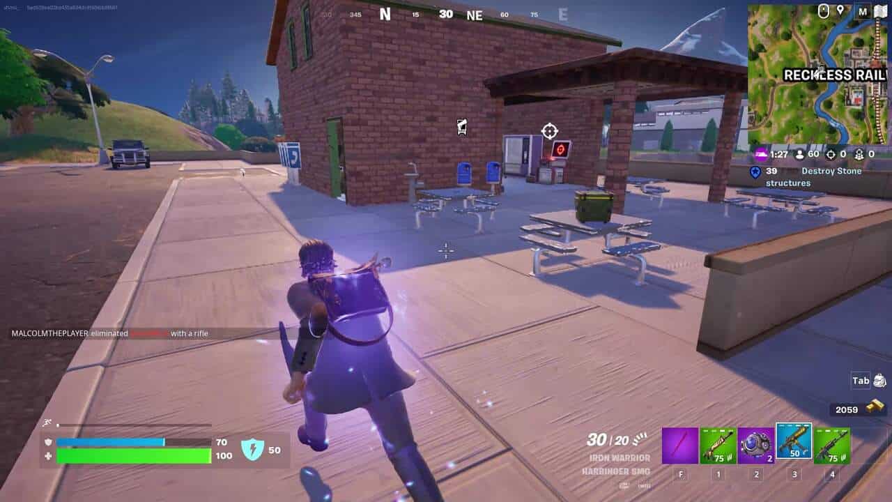 Fortnite best hiding spots: A player running towards a brick building in Fortnite.