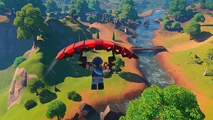 A person is flying over a river using a parachute and LEGO Fortnite Glider for fast travel.